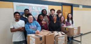 Students involved in the Skills USA pose for a photo with food collection as part of a community outreach program